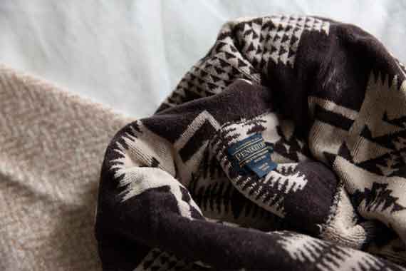 Close-up of a black-and-white geometric wool blanket with a Pendleton tag visible.