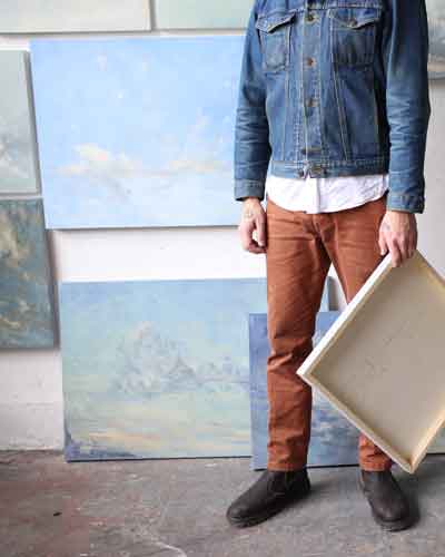 Male painter with paintings of clouds featured at the Atticus Hotel in McMinnville, Oregon